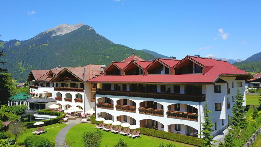 un grand hôtel avec une montagne en arrière-plan dans l'établissement Hotel Alpen Residence, à Ehrwald