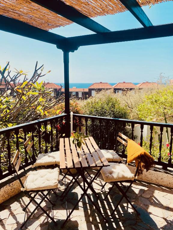 a wooden table and two chairs on a balcony at Finca Gerardo Miramar in La Playa Calera