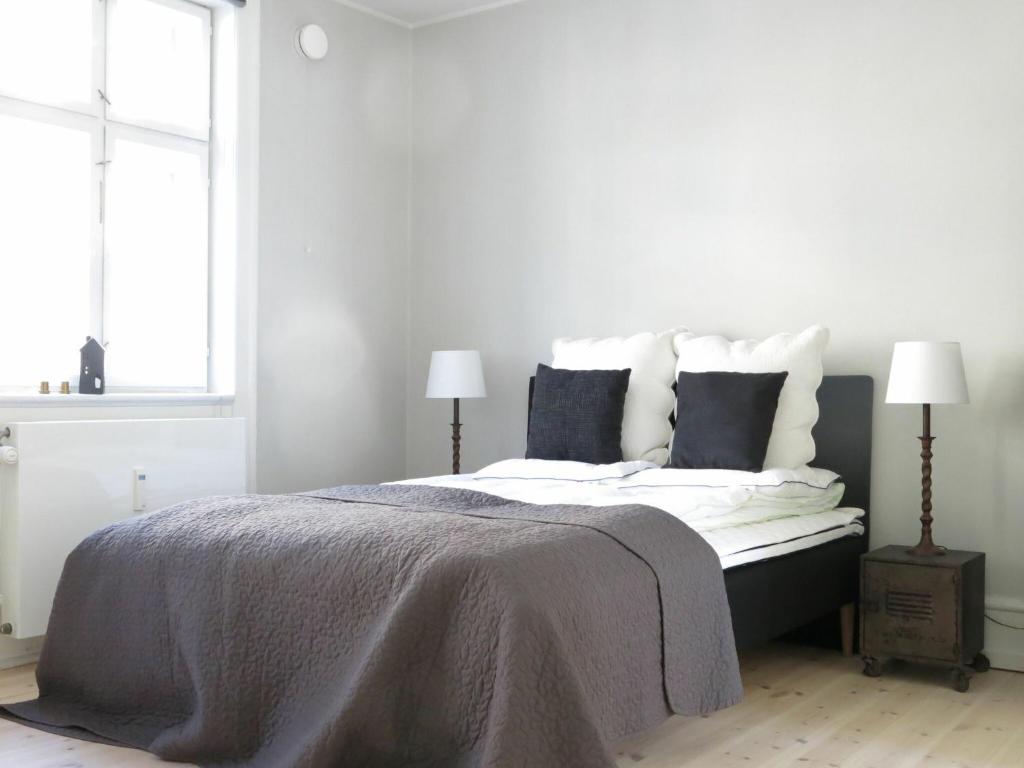 コペンハーゲンにあるApartmentInCopenhagen Apartment 1141の白いベッドルーム(ランプ2つ付きの大型ベッド1台付)