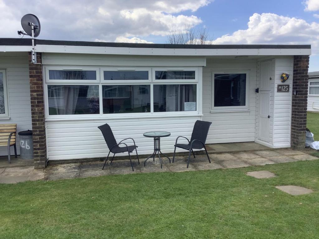 a patio with two chairs and a table in front of a house at 125 Sundowner in Hemsby