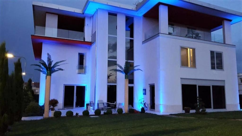 uma grande casa branca com palmeiras em frente em BnB Notte Stellata em Savigliano