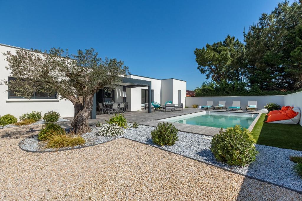 um quintal com uma piscina e uma casa em Villa Paloma em Saint-Palais-sur-Mer