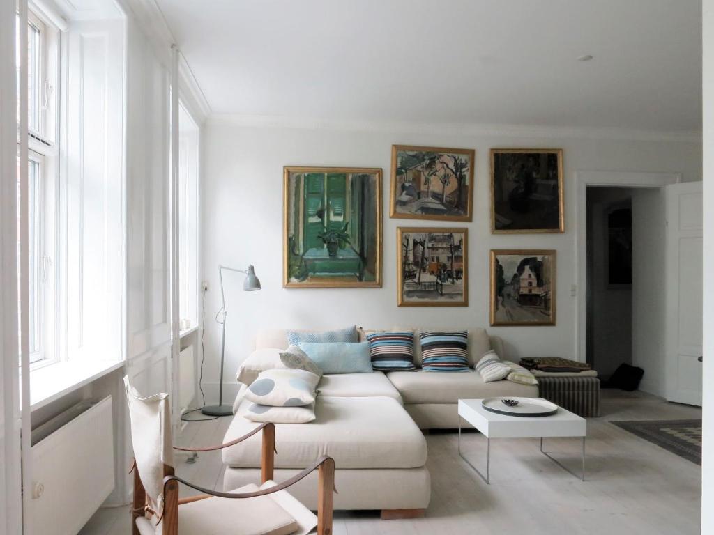 a living room with a white couch and pictures on the wall at ApartmentInCopenhagen Apartment 1389 in Copenhagen