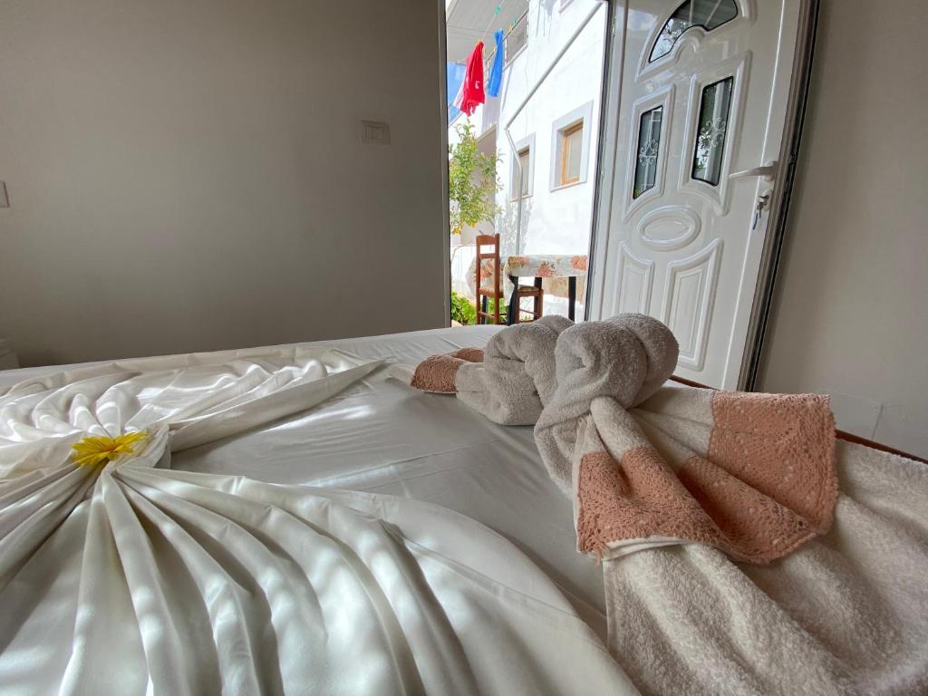 sypialnia z łóżkiem z ręcznikami w obiekcie Guesthouse Mance w mieście Ksamil