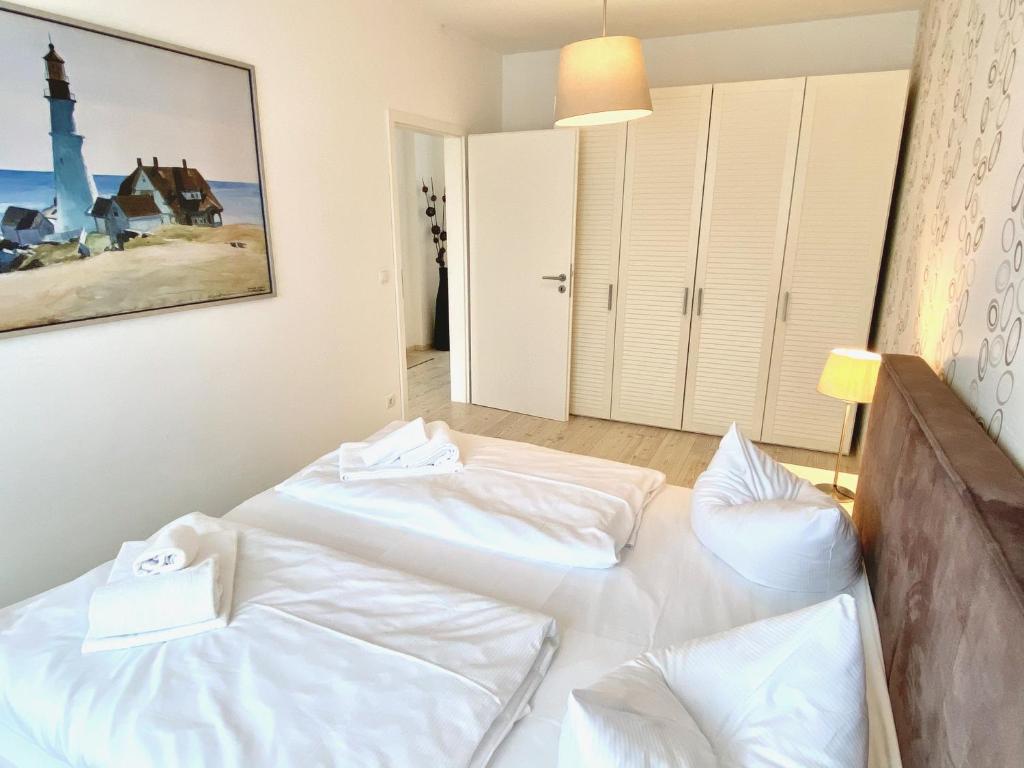 a bedroom with two beds and a painting on the wall at mönchgut living & spa in Gager