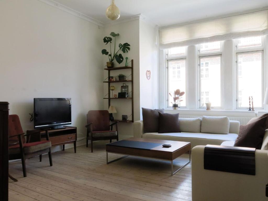 ein Wohnzimmer mit Sofa und Fernseher in der Unterkunft ApartmentInCopenhagen Apartment 1382 in Kopenhagen