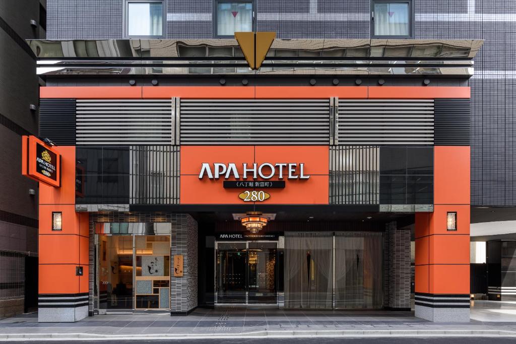 APA Hotel Hatchobori Shintomicho في طوكيو: محل امام مبنى عليه لافته