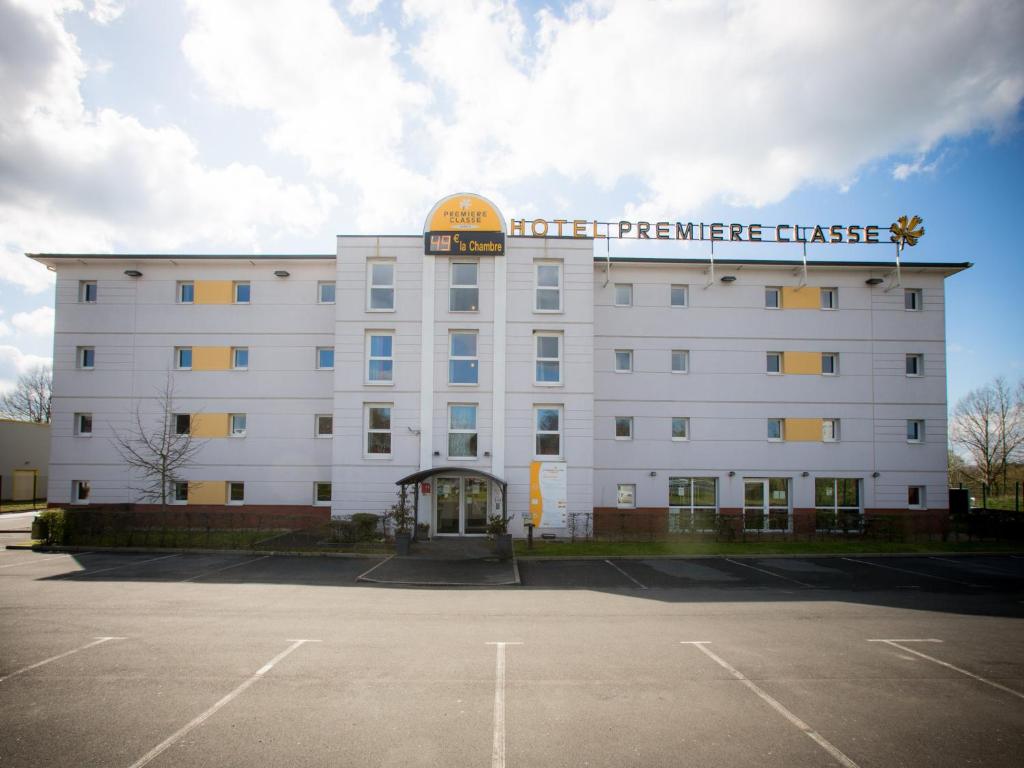 un edificio blanco con un cartel encima en Premiere Classe Lisieux, en Lisieux