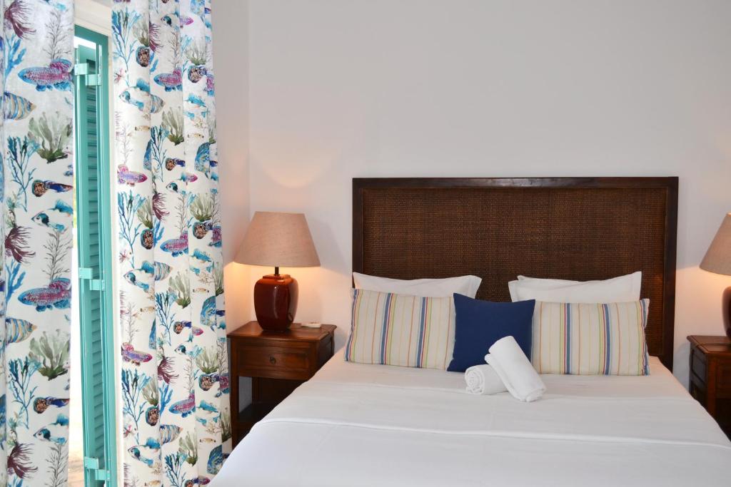 1 dormitorio con 1 cama grande con almohadas azules y blancas en M&L Beach House en Alvor