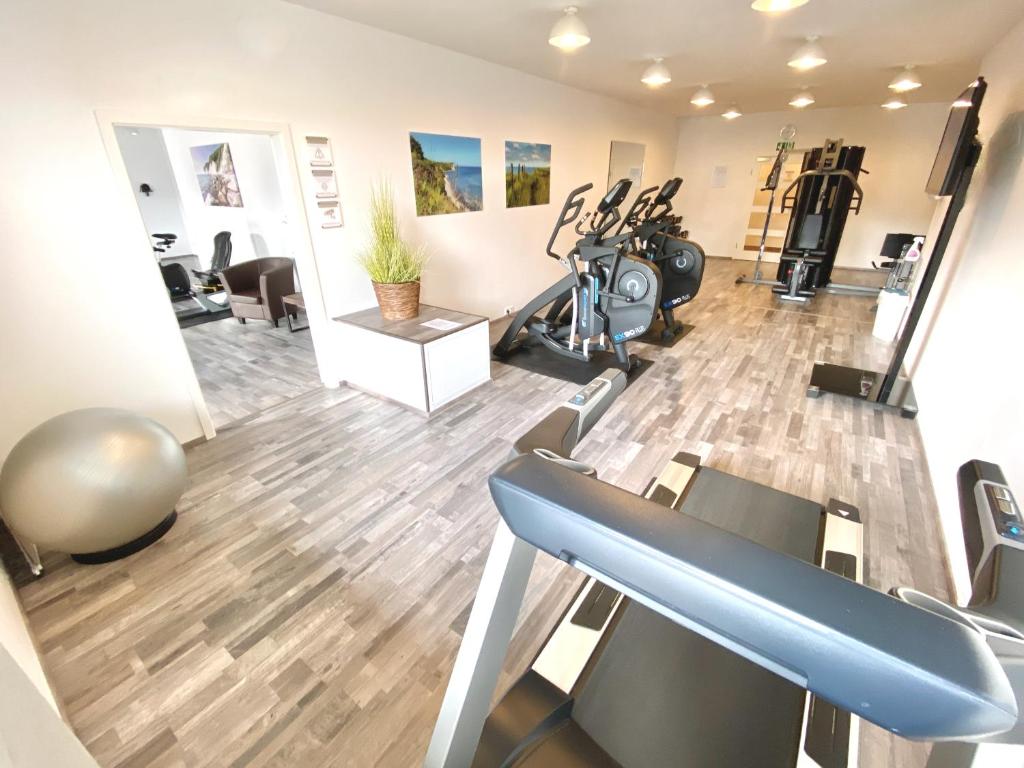 a gym with treadmills and exercise equipment in a room at mönchgut living & spa in Gager