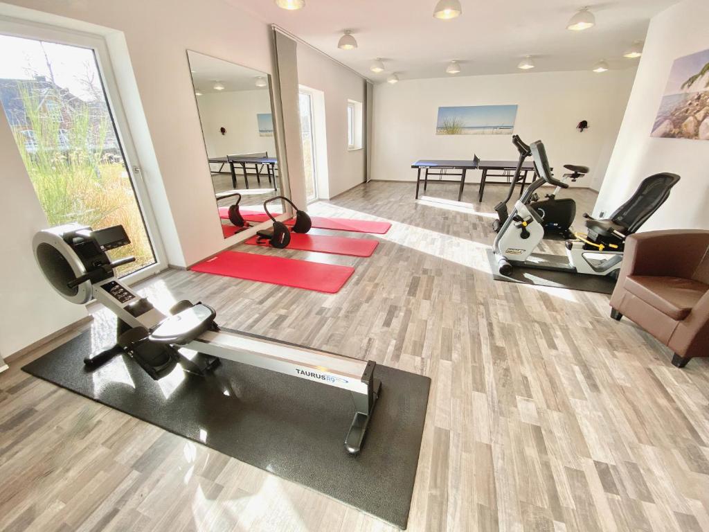 a gym with treadmills and exercise equipment in a room at mönchgut living & spa in Gager