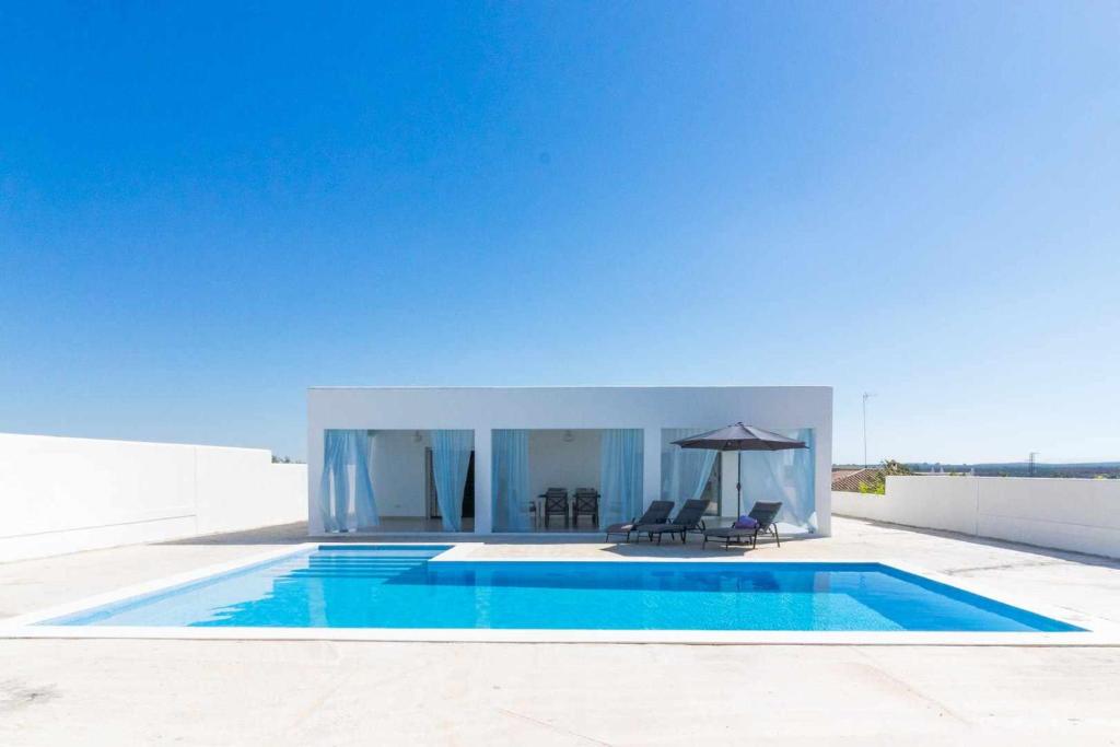 Casa con piscina con mesa y sillas en Casa Rural Villa MyJ, en La Puebla de Cazalla