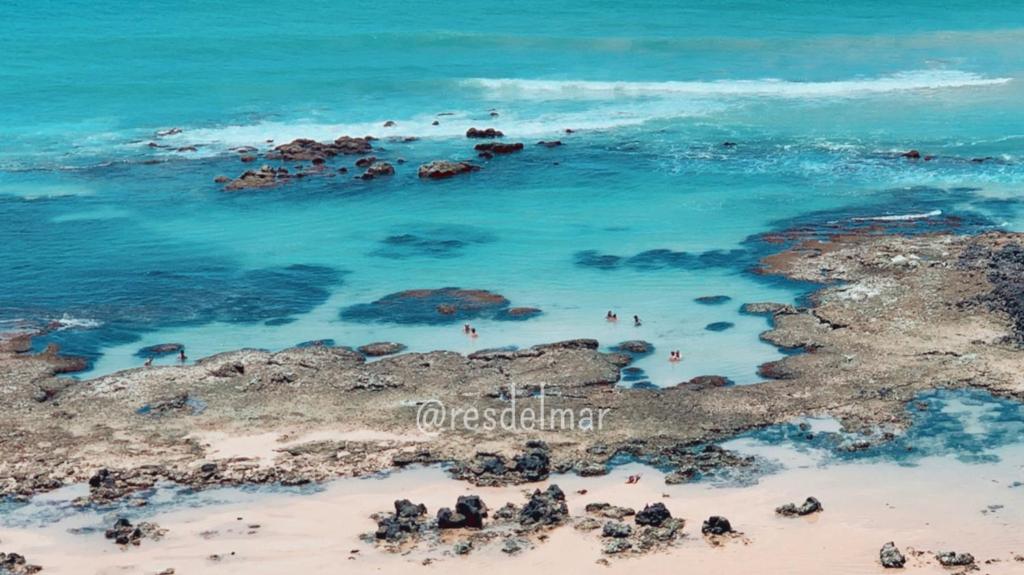 an aerial view of a beach with rocks and the ocean at Pousada ResDelMar in Baía Formosa