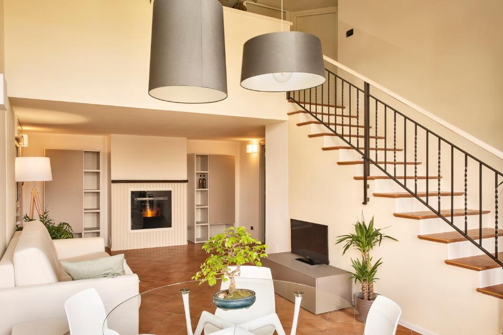 a living room with white furniture and a staircase at Ypa Home Lago di Candia Canavese in Candia Canavese