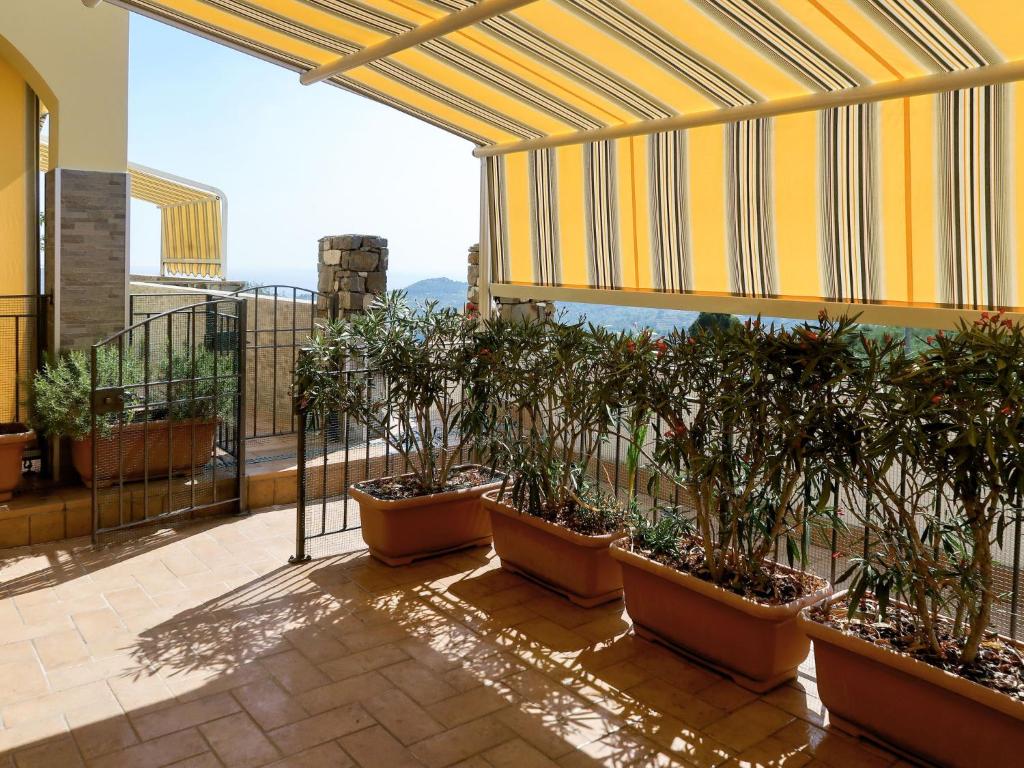 un balcone con un mucchio di piante in vasi di Apartment Samuele by Interhome a Civezza