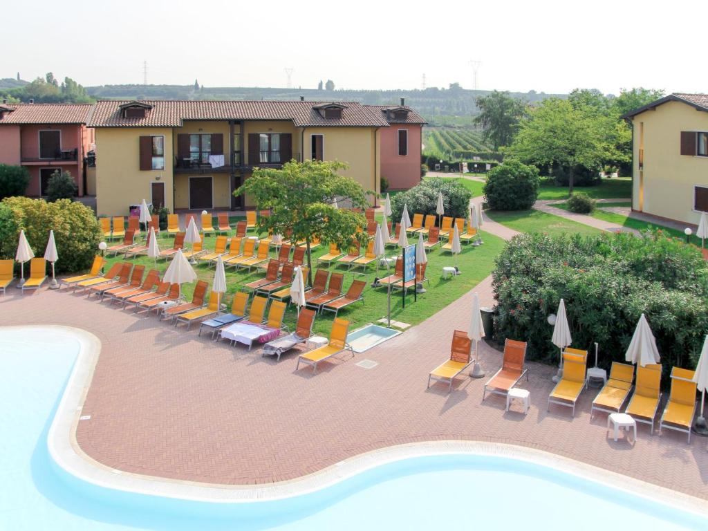ein Resort mit Stühlen und Sonnenschirmen sowie einem Pool in der Unterkunft Apartment Eden by Interhome in Cavalcaselle