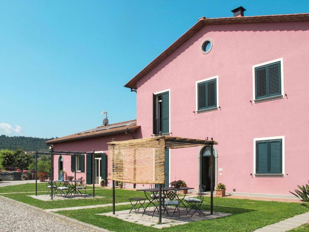 ein rosafarbenes Haus mit einem Picknicktisch davor in der Unterkunft Apartment Sabrina by Interhome in San Quirico di Moriano
