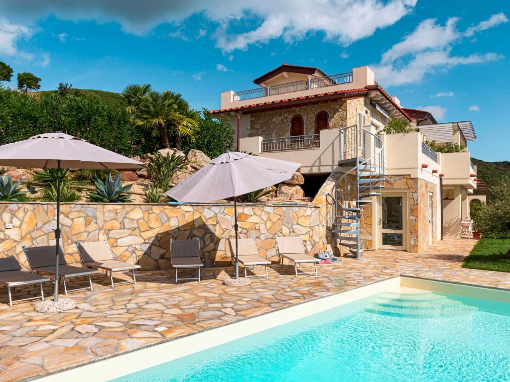 eine Villa mit einem Pool und einem Haus in der Unterkunft Apartment Stella - Villa di Sogno by Interhome in Capoliveri
