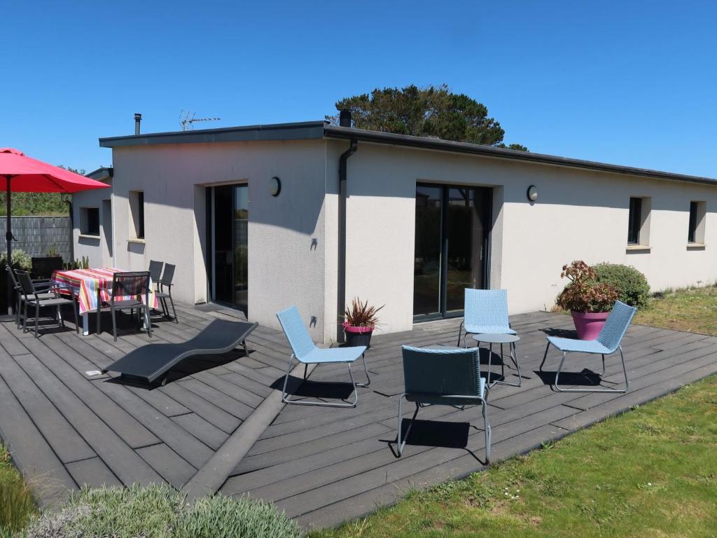 une terrasse avec des chaises et des tables et un bâtiment dans l'établissement Holiday Home Ty Amiets by Interhome, à Cléder