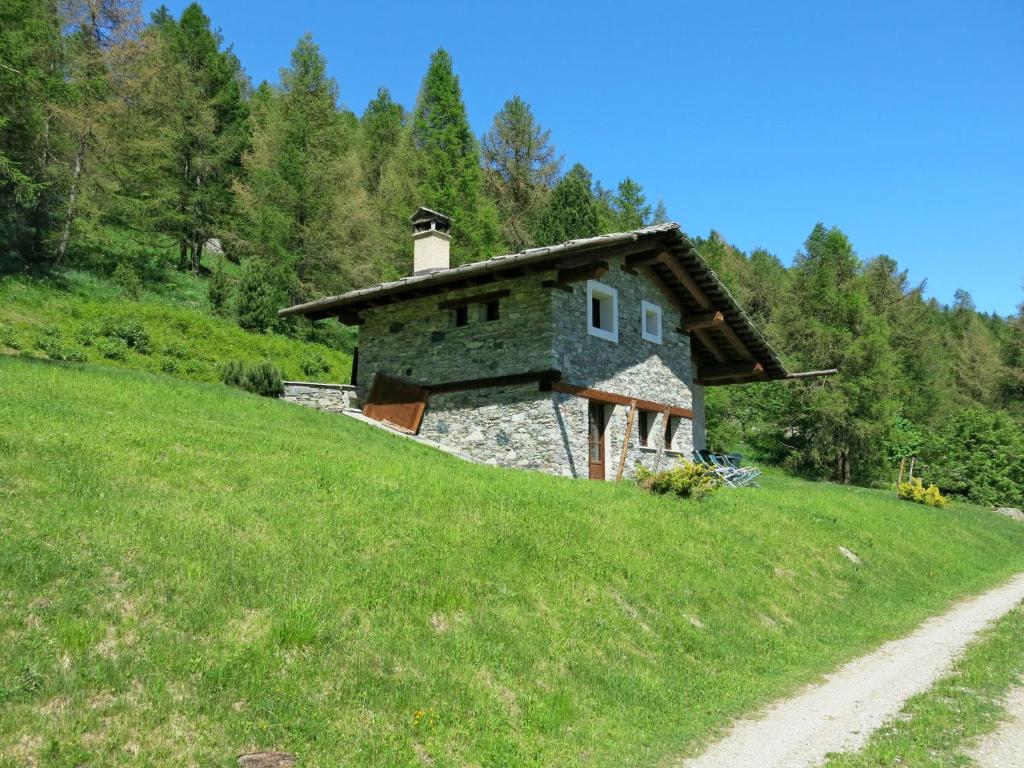 uma casa de pedra numa colina com uma estrada de terra em Chalet Casot Pra Viei - SMY100 by Interhome em Sampeire