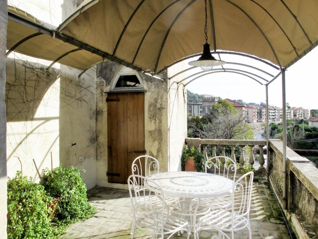 un patio con mesa y sillas bajo una sombrilla en Apartment Ginevra - FLG209 by Interhome en Finale Ligure