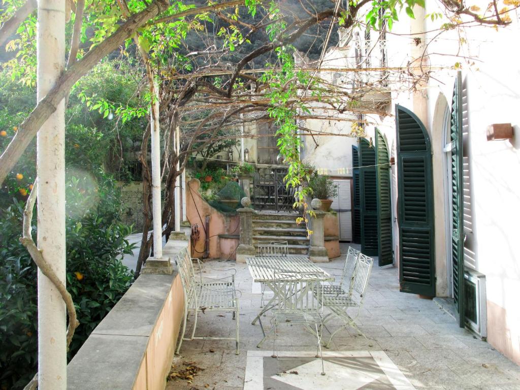 een terras met stoelen, bomen en trappen bij Apartment Camelot - FLG204 by Interhome in Finale Ligure
