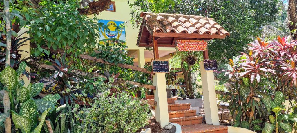 un jardín con una casa de aves y muchas plantas en Hotel Iguanito, en Santa Catalina