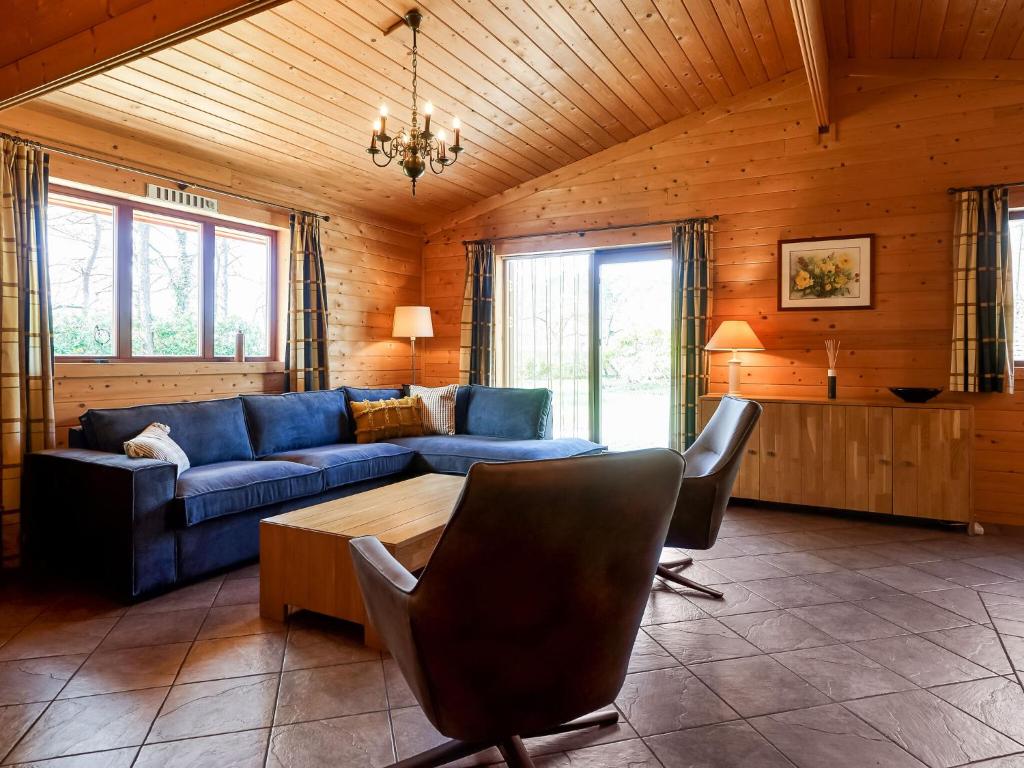 un soggiorno con divano blu e tavolo di Finnish house with enclosed garden near the Salland Ridge a Holten