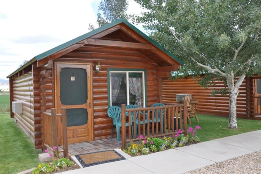 eine Blockhütte mit einer Veranda und einer Terrasse in der Unterkunft Bryce Country Cabins in Tropic