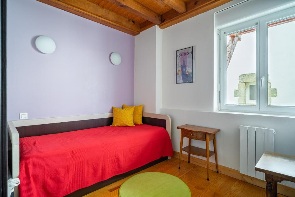 a bedroom with a red bed and a window at MAGNOLIAS 2- quartier résidentiel proche de la plage in Hendaye