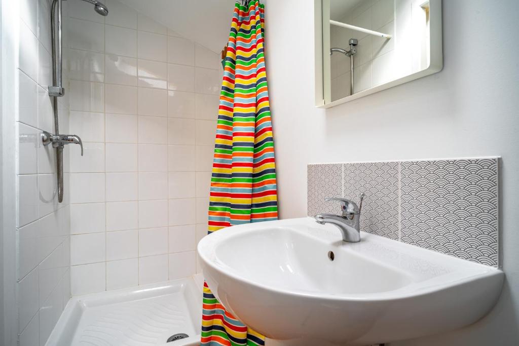 a bathroom with a sink and a shower curtain at MAGNOLIAS 2- quartier résidentiel proche de la plage in Hendaye