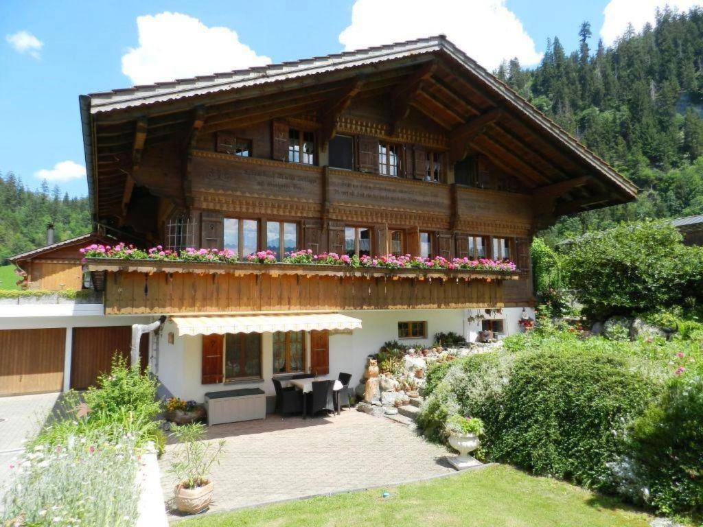 a large wooden house with flowers on the balcony at Apartment Giferblick by Interhome in Zweisimmen