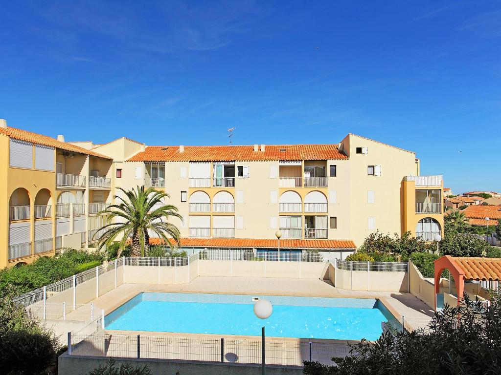 un grand immeuble d'appartements avec une grande piscine dans l'établissement Apartment Les Maisons sur la Plage-9 by Interhome, à Narbonne-Plage