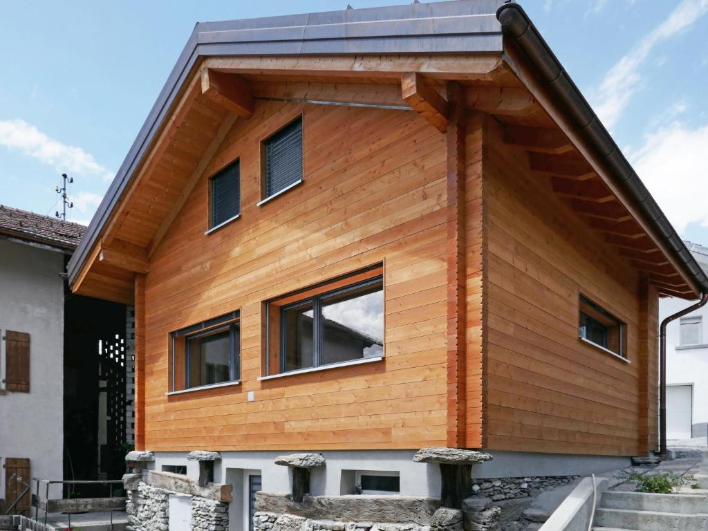 una casa revestida de madera con techo de gambrel en Chalet Le Raccard by Interhome, en Savièse