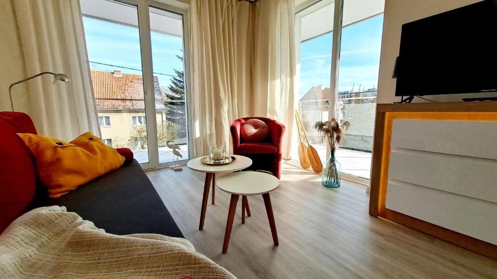 a living room with a tv and a chair and a table at Apartament Mazurskie Piaski in Giżycko