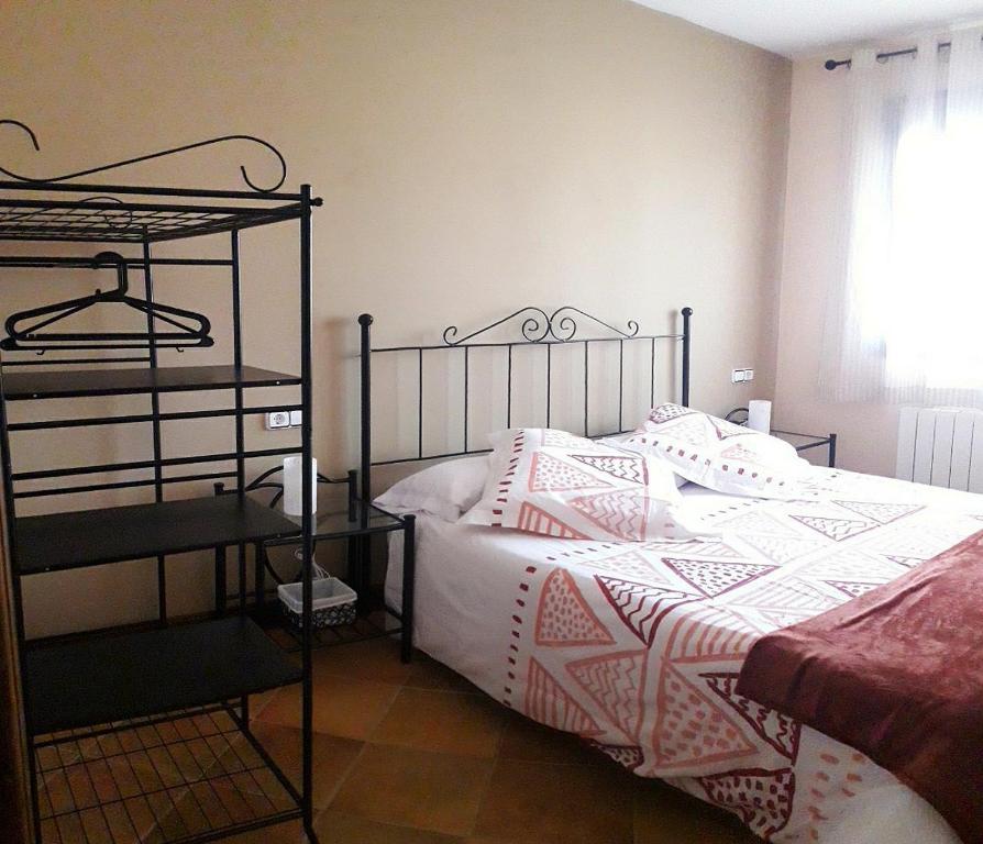 1 dormitorio con 1 cama con almohadas rosas y blancas en Casa Los Miradores, en Las Majadas