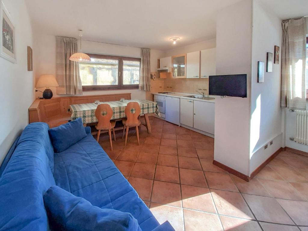 a living room with a blue couch and a kitchen at Apartment Roacia by Interhome in Alba di Canazei