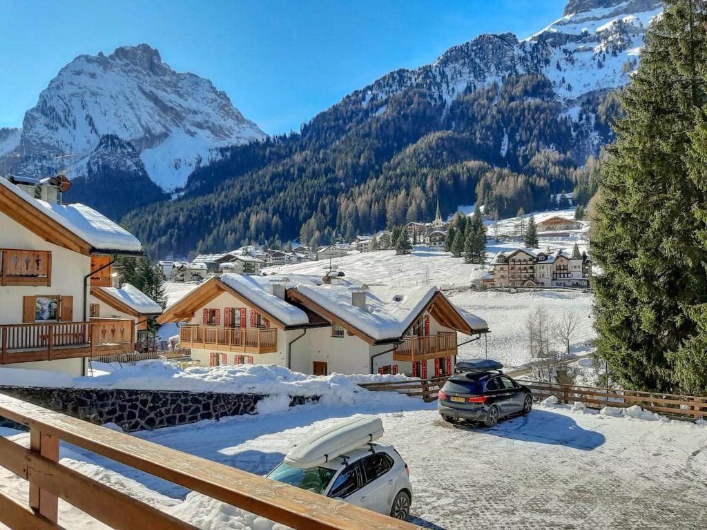 a snow covered village with mountains in the background at Apartment Roacia-2 by Interhome in Alba di Canazei