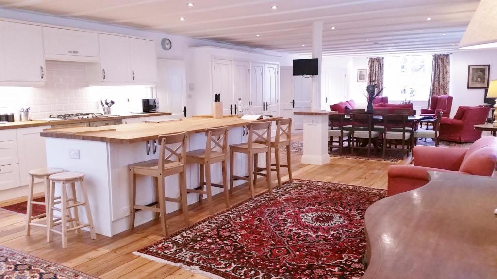 a kitchen and living room with a bar and a table at East End House in Bury Saint Edmunds