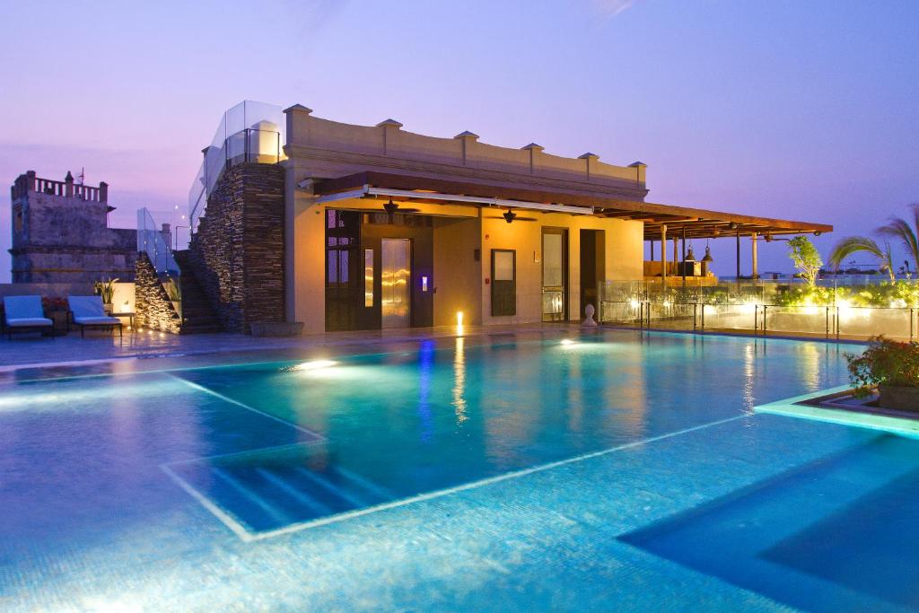 a swimming pool in front of a house at night at Bastión Luxury Hotel in Cartagena de Indias
