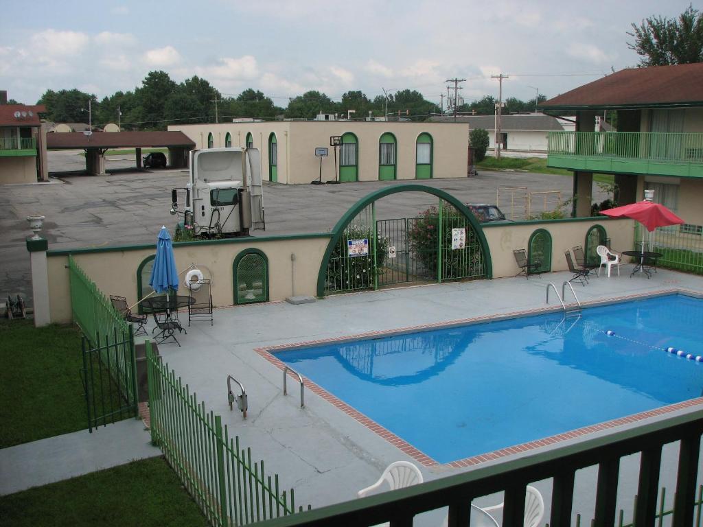 a large swimming pool in front of a building at Canterbury Inn & Suites in Parsons