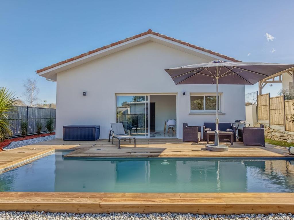 une maison avec une piscine et un parasol dans l'établissement Holiday Home La Bruyère by Interhome, à Saubion