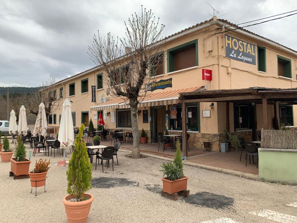 un edificio con mesas, sillas y sombrillas en La Laguna en Uña