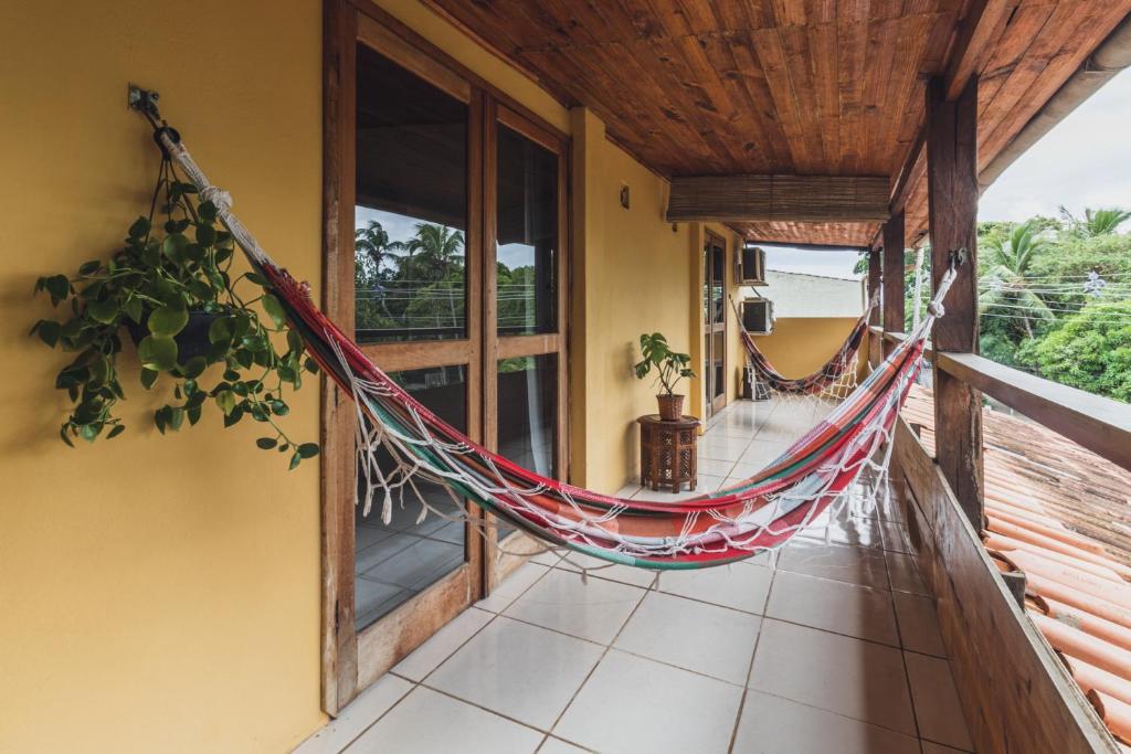 a hammock on the porch of a house at Pousada La Cabana in Itacaré