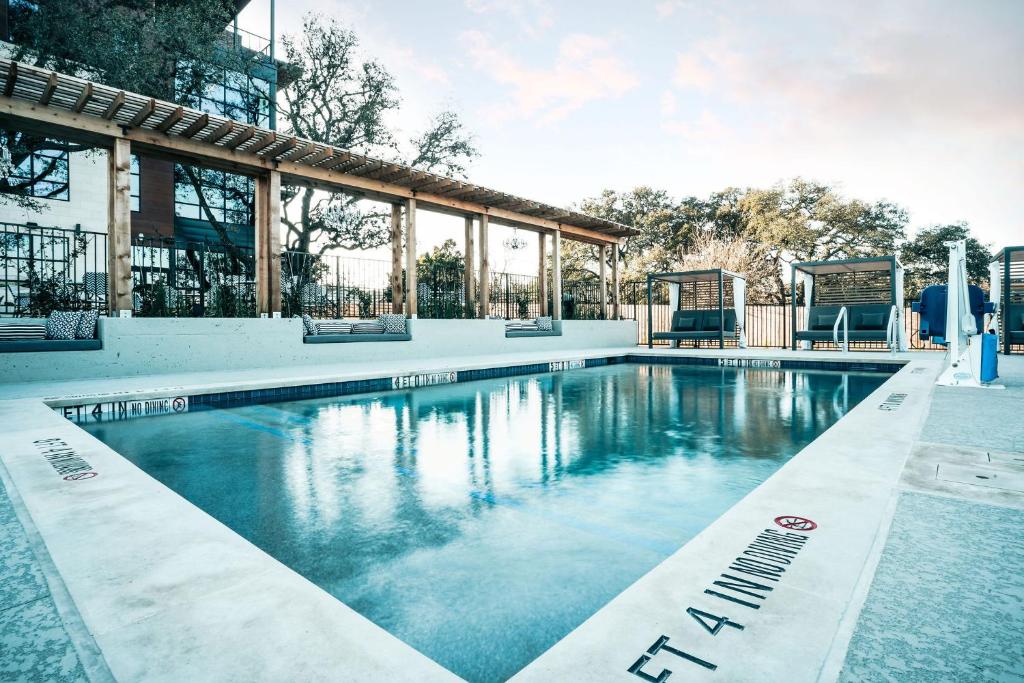 a swimming pool with blue water in front of a building at Colton House Hotel in Austin