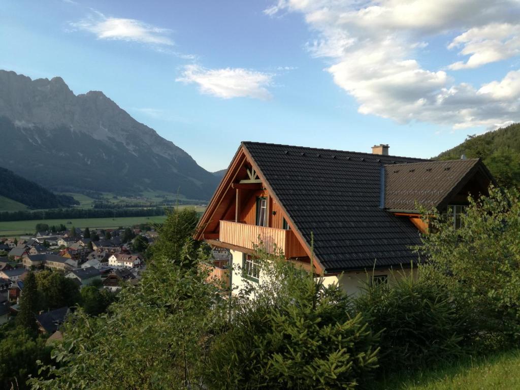 dom na wzgórzu z górami w tle w obiekcie Grimming Appartement Schladming w mieście Sonnberg