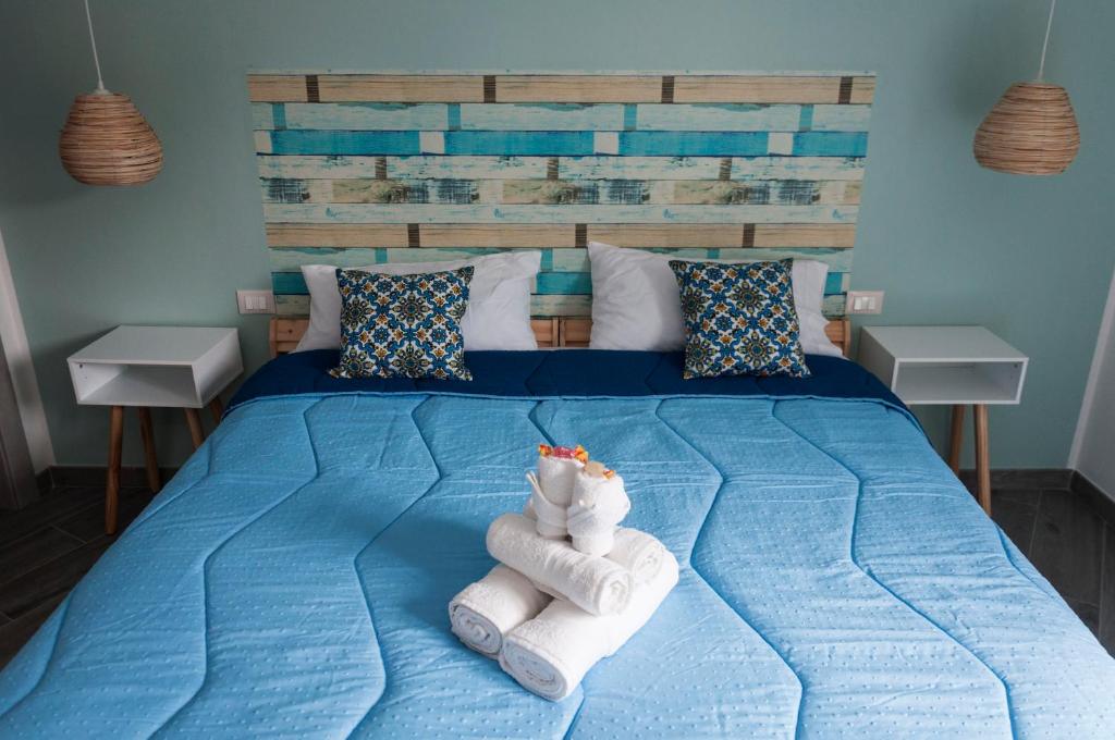 una camera da letto con un letto blu e asciugamani di La Piccola Formica Charme Rooms a Palermo