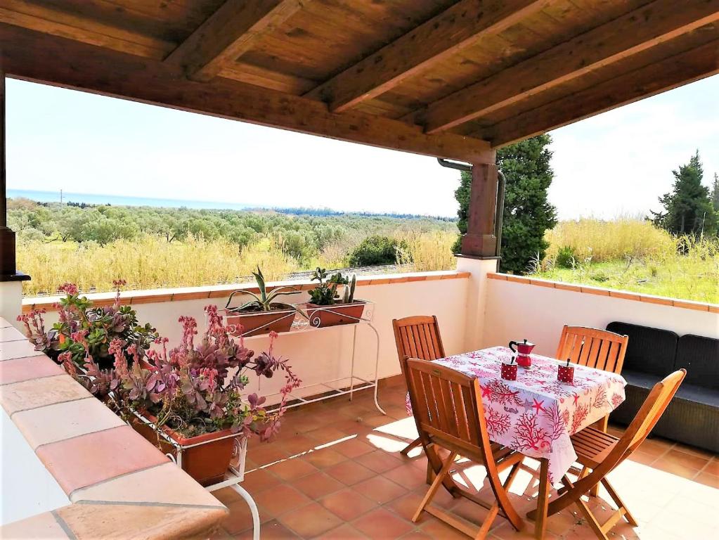 un patio con tavolo e sedie sul balcone. di LudoMar Country Residence - Rooms & Apartments a SantʼAndrea Apostolo dello Ionio