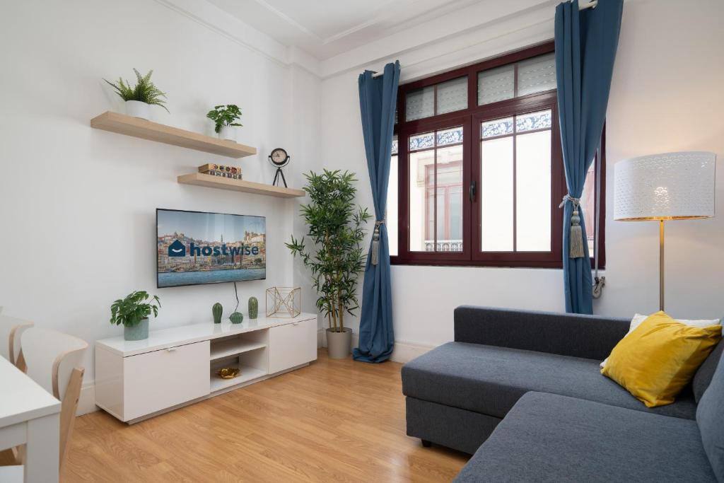 sala de estar con sofá y ventana en Spacious Comfortable Apartment - Balcony en Oporto