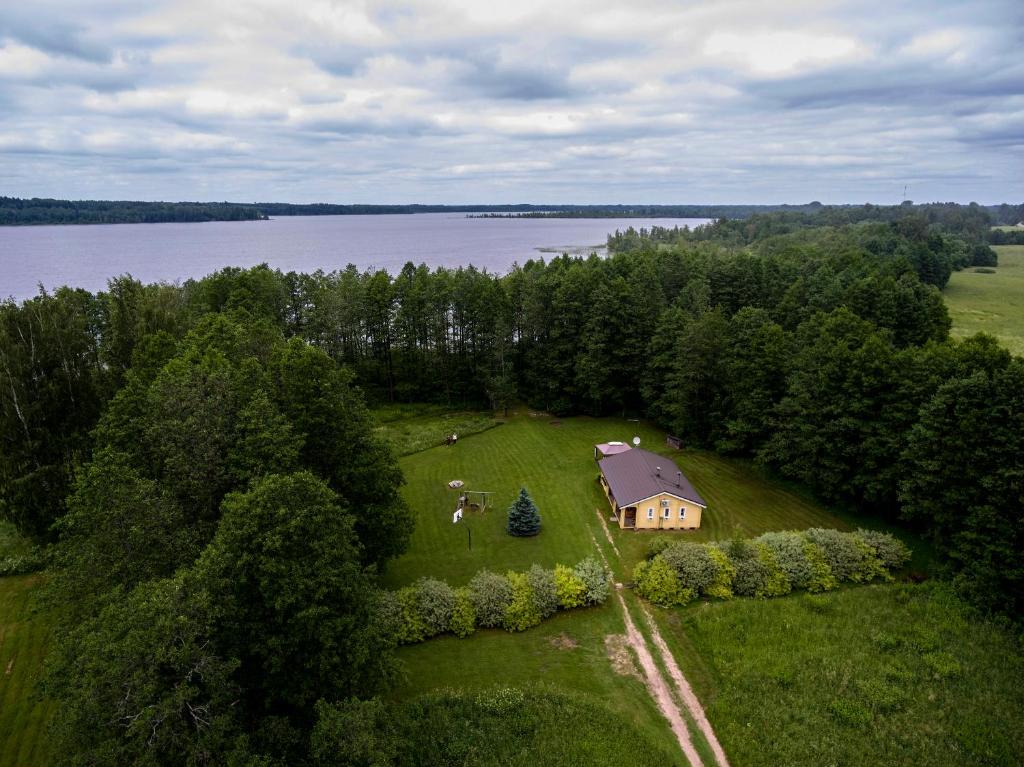 an aerial view of a house on a field next to a lake at Ezerzemes in Nirza